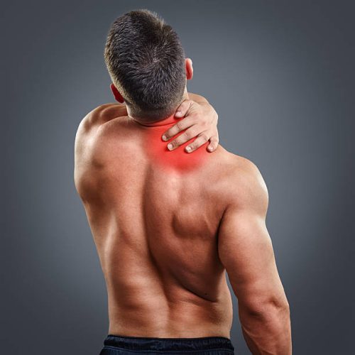 Back view portrait of a man with neck pain over gray background. Concept with highlighted glowing red spot.